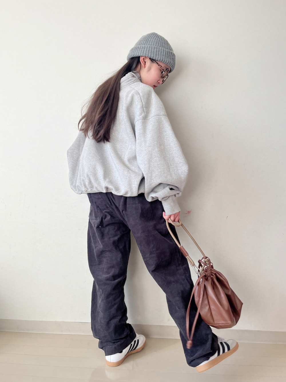 グレー系のスウェット、グレー系のその他パンツ、ブラウン系のショルダーバッグを着用したキッズの冬コーディネートの3枚目の写真