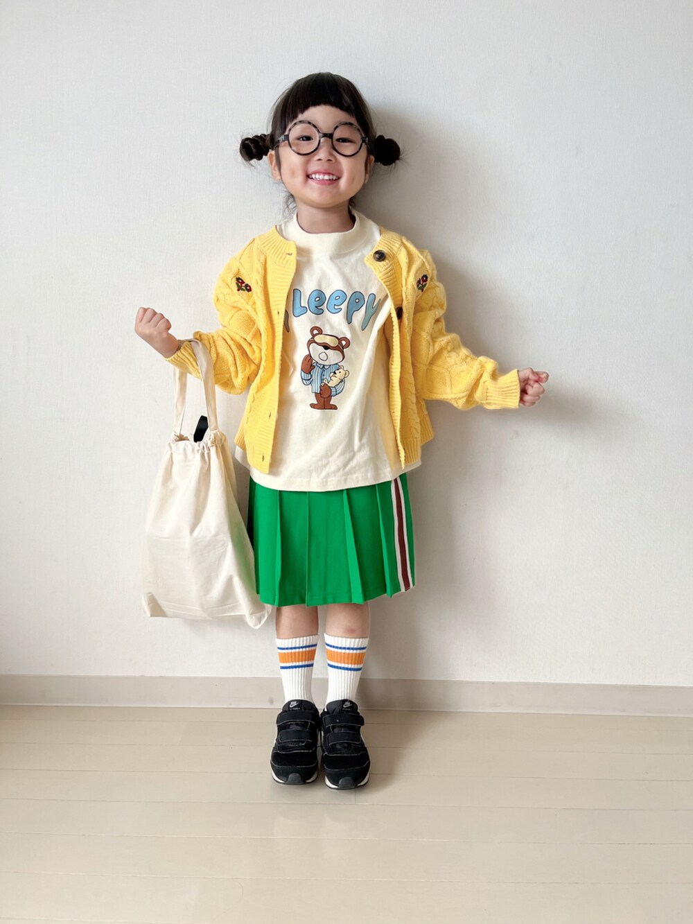 ホワイト系のTシャツ/カットソー、グリーン系のスカート、ブラック系のスニーカーを着用したキッズの秋コーディネートの4枚目の写真