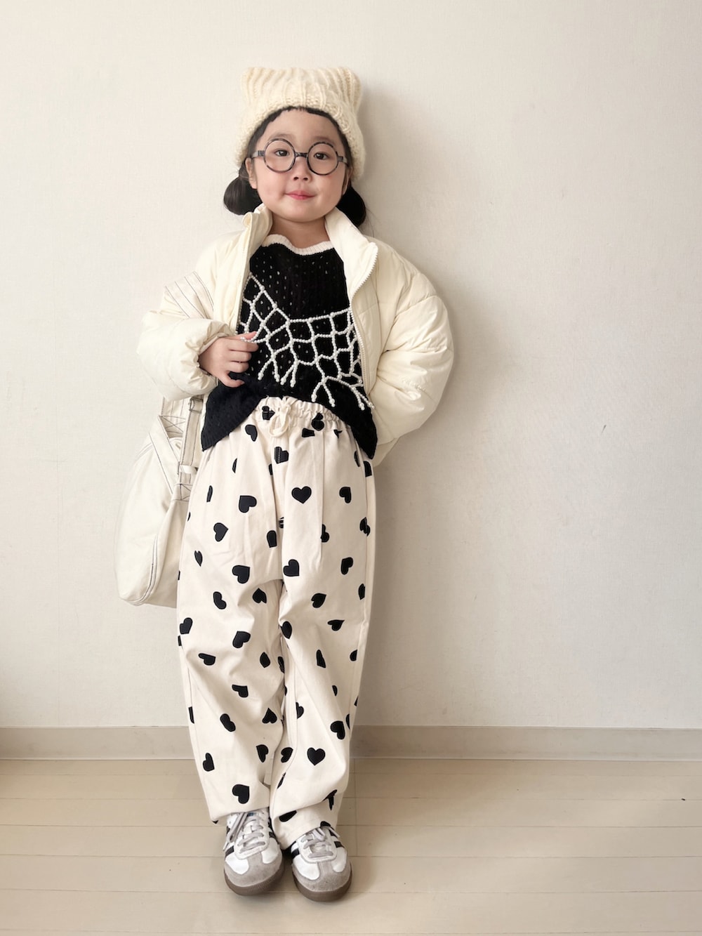 ホワイト系のダウンジャケット/コート、ホワイト系のその他パンツ、ブラック系のニット/セーターを着用したキッズの冬コーディネートの2枚目の写真