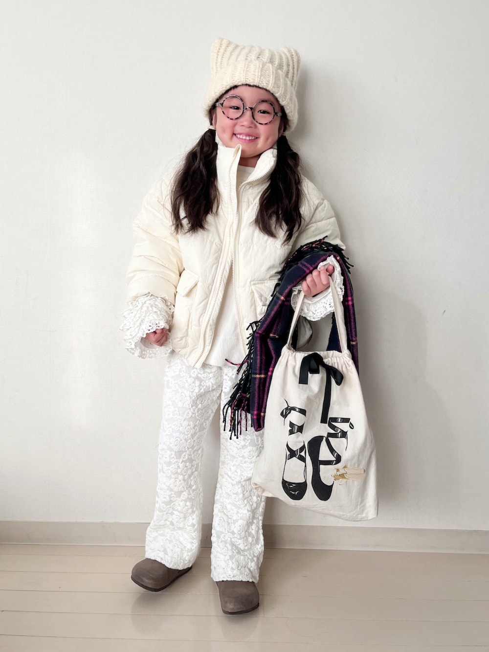 ホワイト系のダウンジャケット/コート、ホワイト系のニット/セーター、ホワイト系のTシャツ/カットソーを着用したキッズの冬コーディネートの3枚目の写真