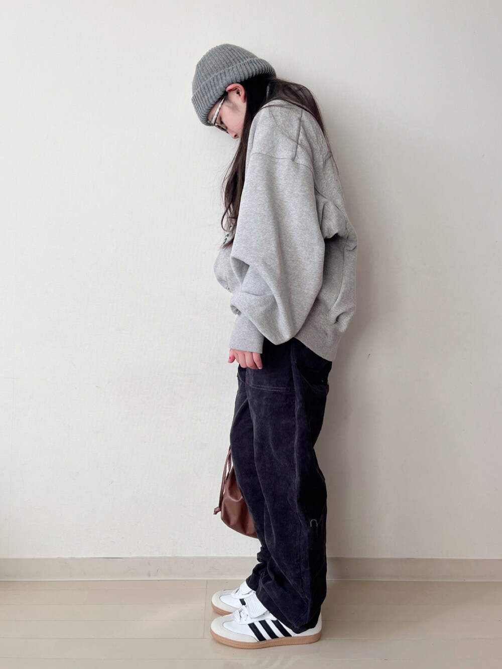 グレー系のスウェット、グレー系のその他パンツ、ブラウン系のショルダーバッグを着用したキッズの冬コーディネートの4枚目の写真