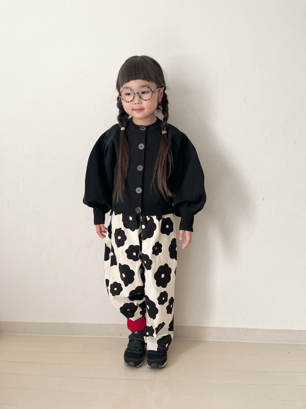 ホワイト系のその他パンツ、ブラック系のカーディガン/ボレロ、ブラック系のスニーカーを着用したキッズの冬コーディネートの4枚目の写真