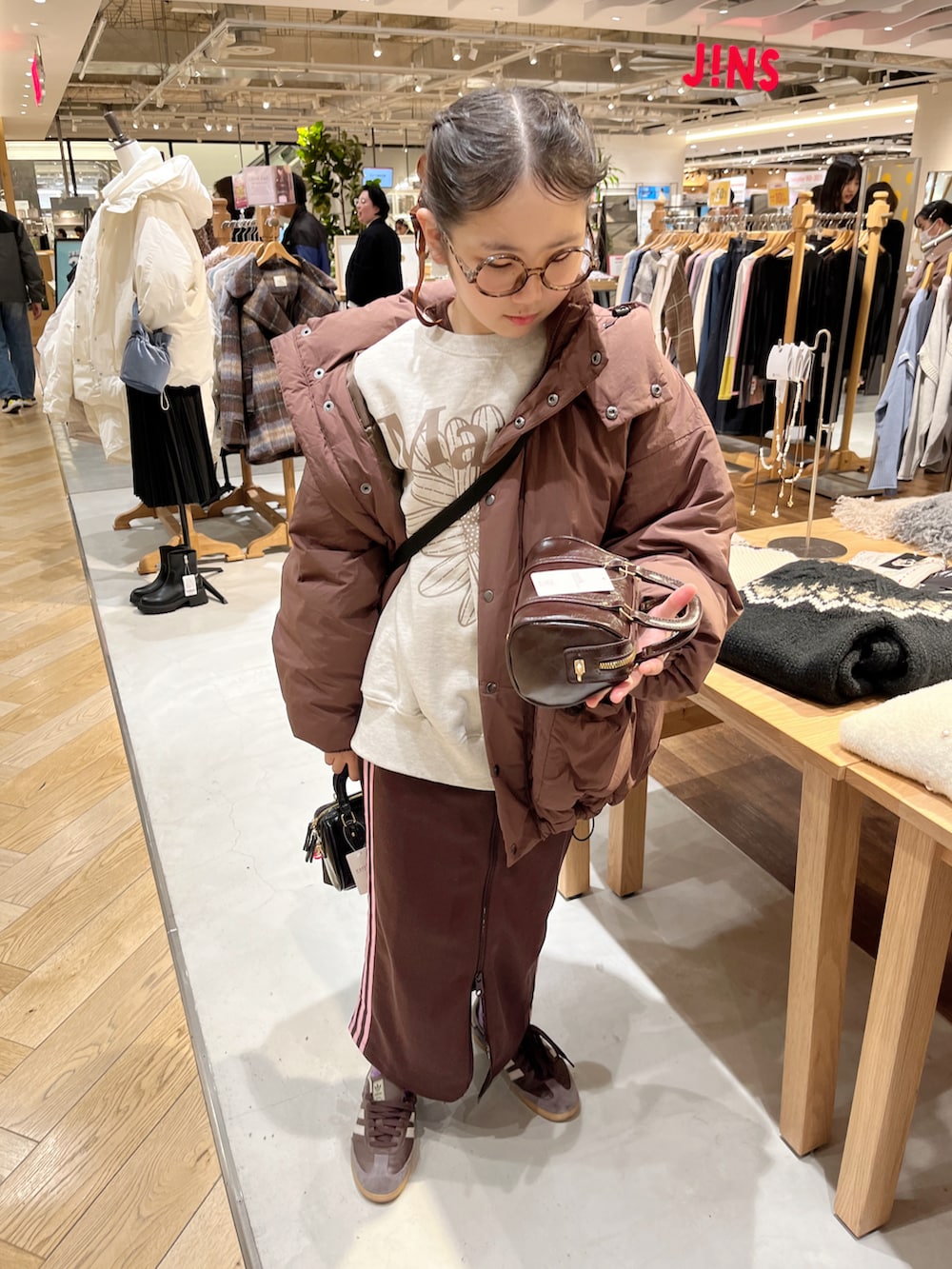 ベージュ系のスウェット、ブラウン系のブルゾン、ブラウン系のスカートを着用したキッズの冬コーディネートの3枚目の写真