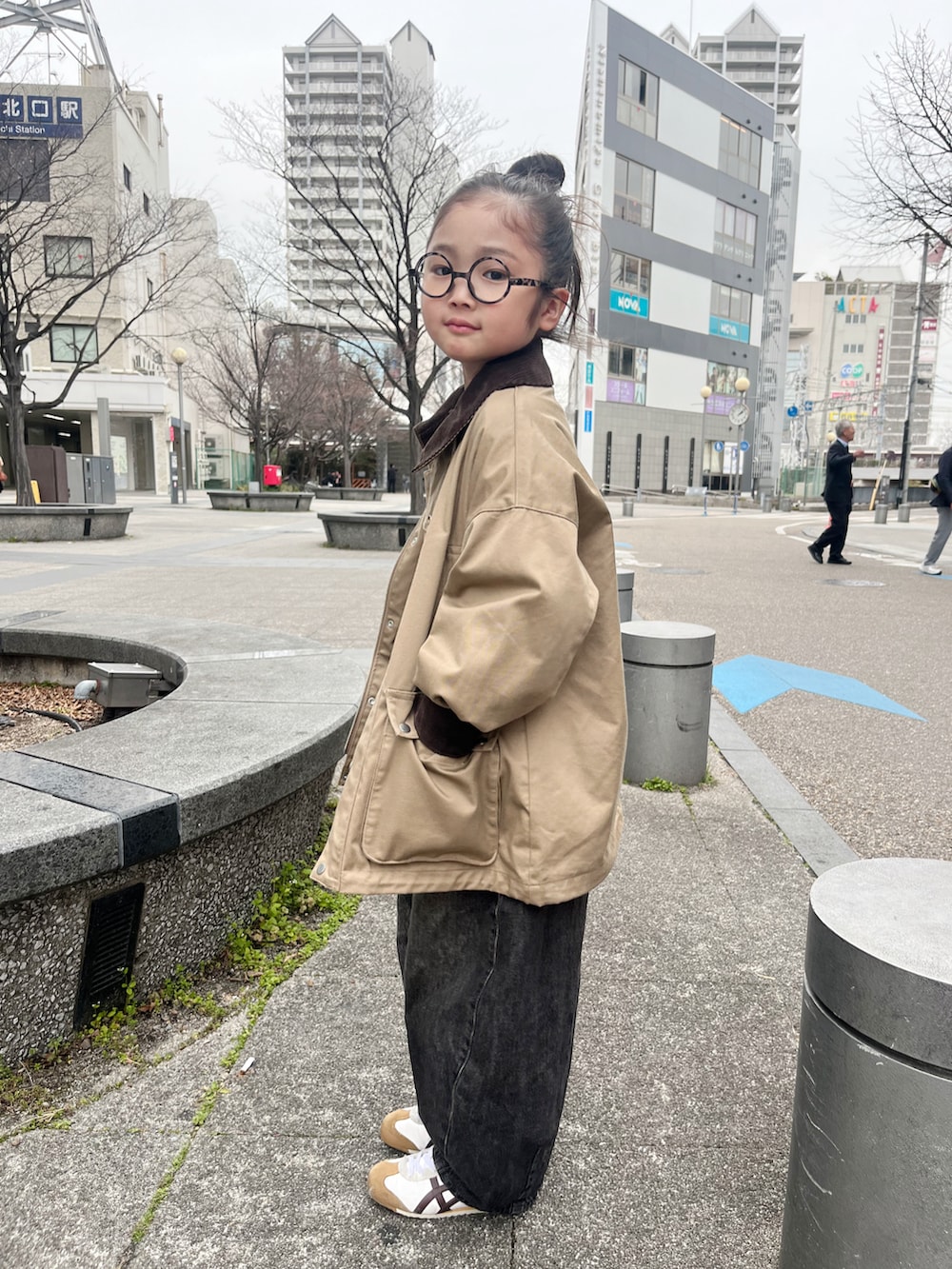 ブラック系のTシャツ/カットソー、ホワイト系のスニーカー、ベージュ系のミリタリージャケットを着用したキッズの春コーディネートの2枚目の写真