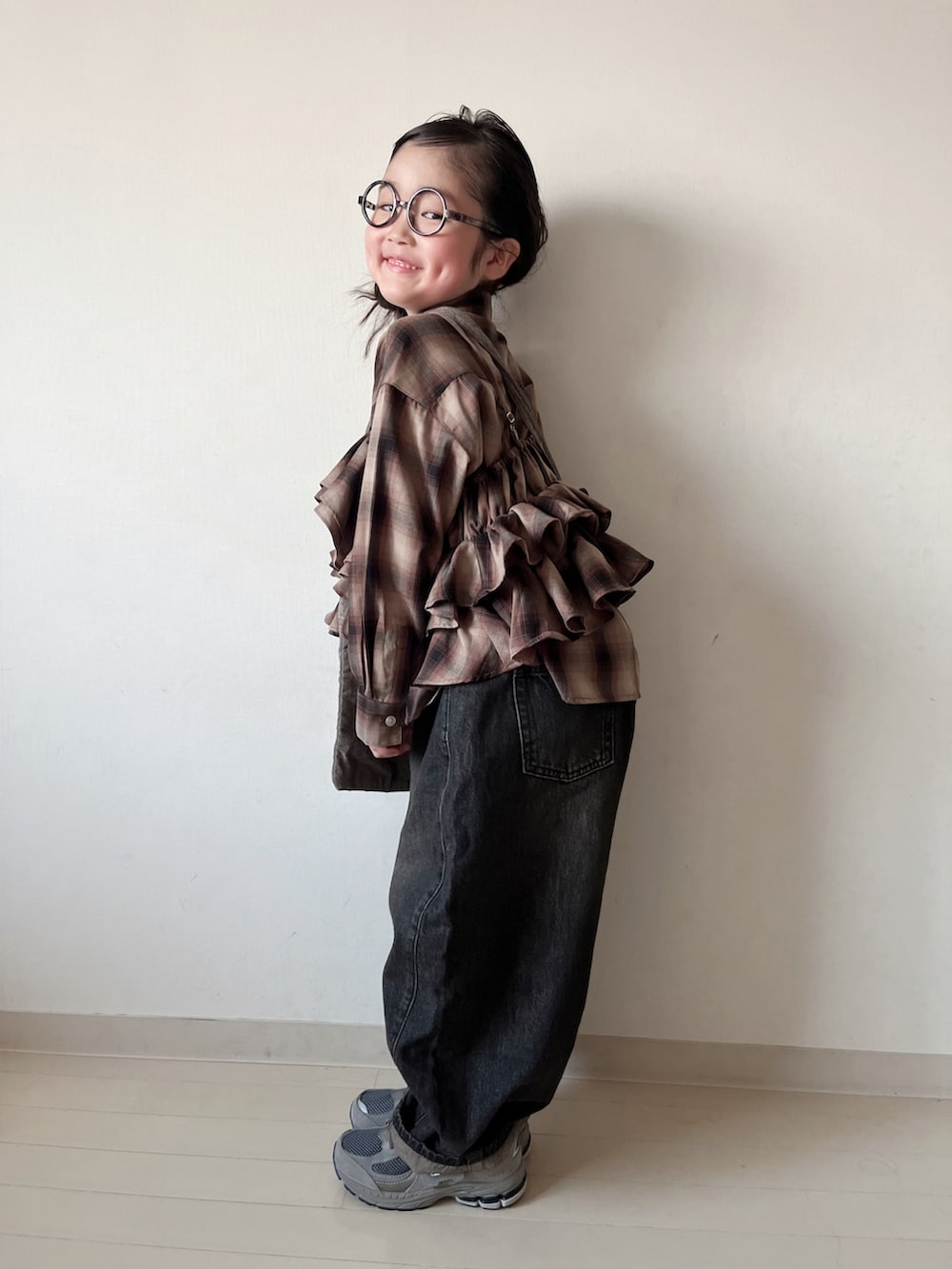 ブラウン系のシャツ/ブラウス、ブラック系のデニムパンツ、ブラウン系のキャミソールを着用したキッズの秋コーディネートの3枚目の写真