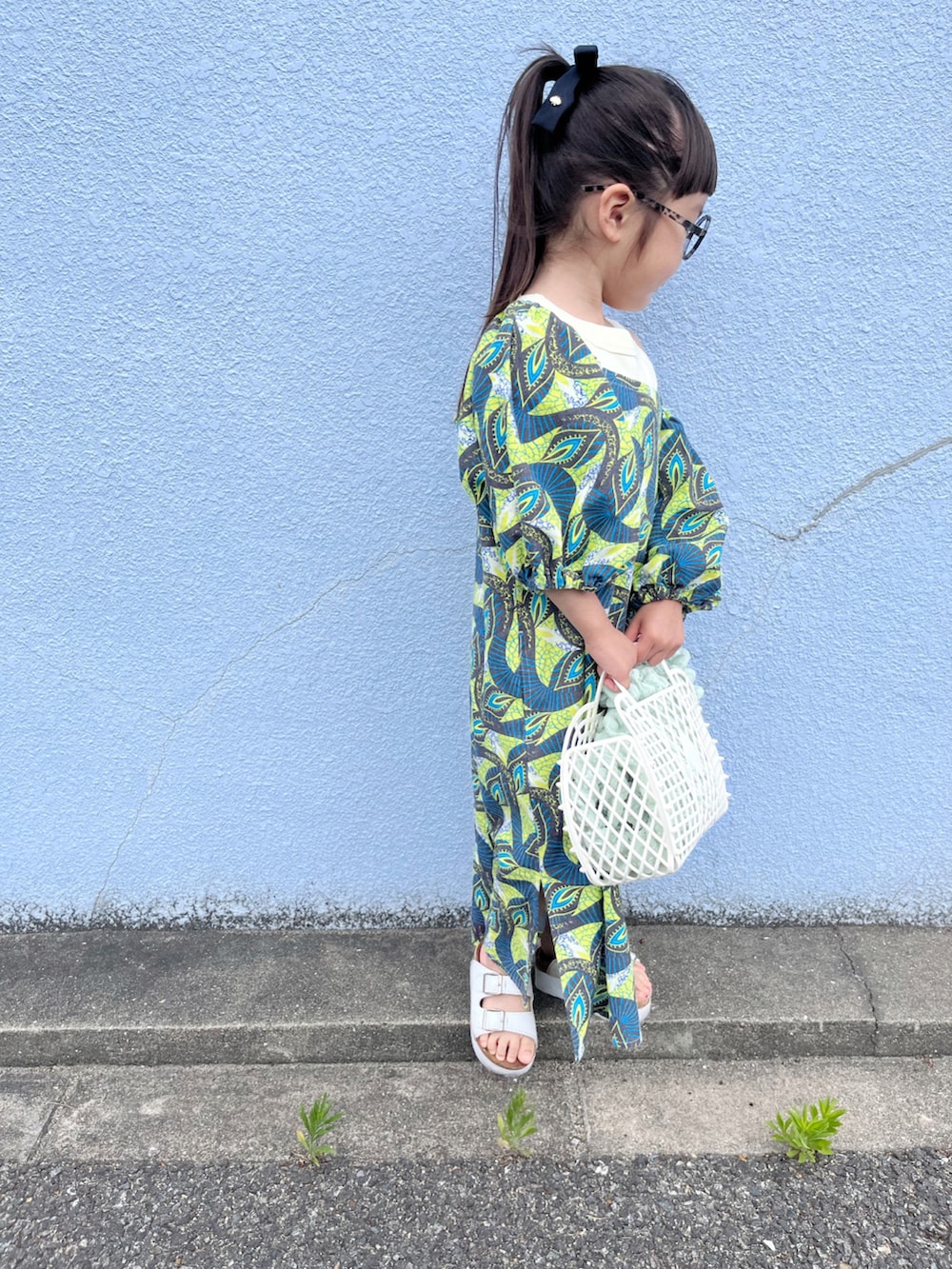 イエロー系のワンピース、ホワイト系のタンクトップ、グリーン系のカーディガン/ボレロを着用したキッズの春コーディネートの4枚目の写真