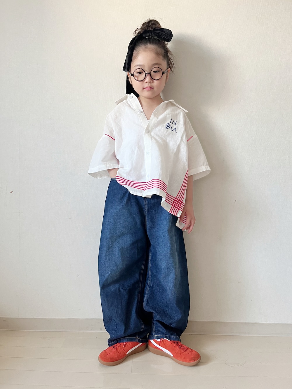 ホワイト系のシャツ/ブラウス、ブルー系のデニムパンツ、レッド系のスニーカーを着用したキッズの春コーディネートの3枚目の写真