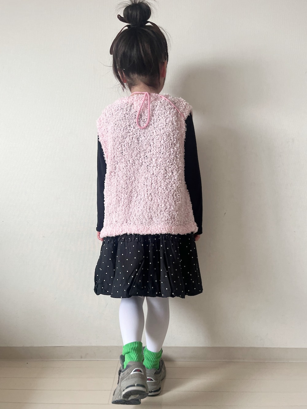 ピンク系のニット/セーター、ブラック系のスカート、グレー系のスニーカーを着用したキッズの冬コーディネートの5枚目の写真