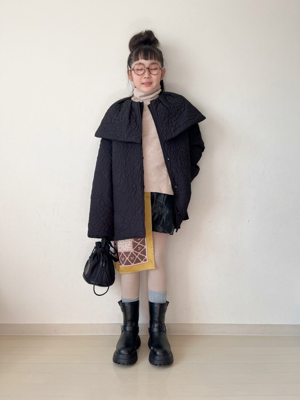 ブラック系のブーツ、ブラック系のその他パンツ、ベージュ系のニット/セーターを着用したキッズの冬コーディネートの2枚目の写真