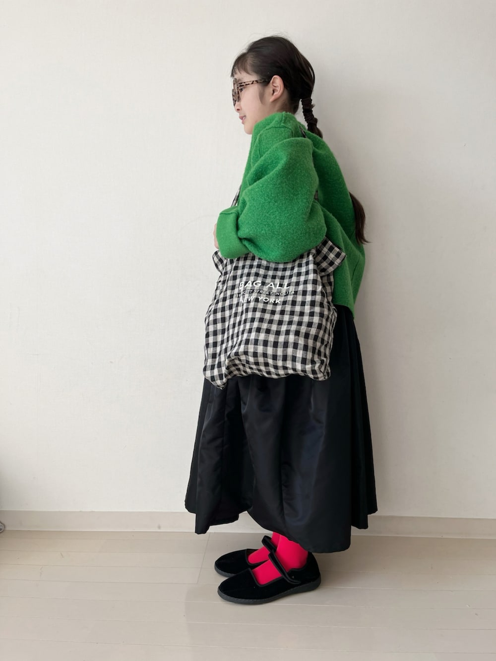 ブラック系のスカート、ブラック系のバッグ、レッド系のタイツ/ストッキングを着用したキッズの冬コーディネートの3枚目の写真