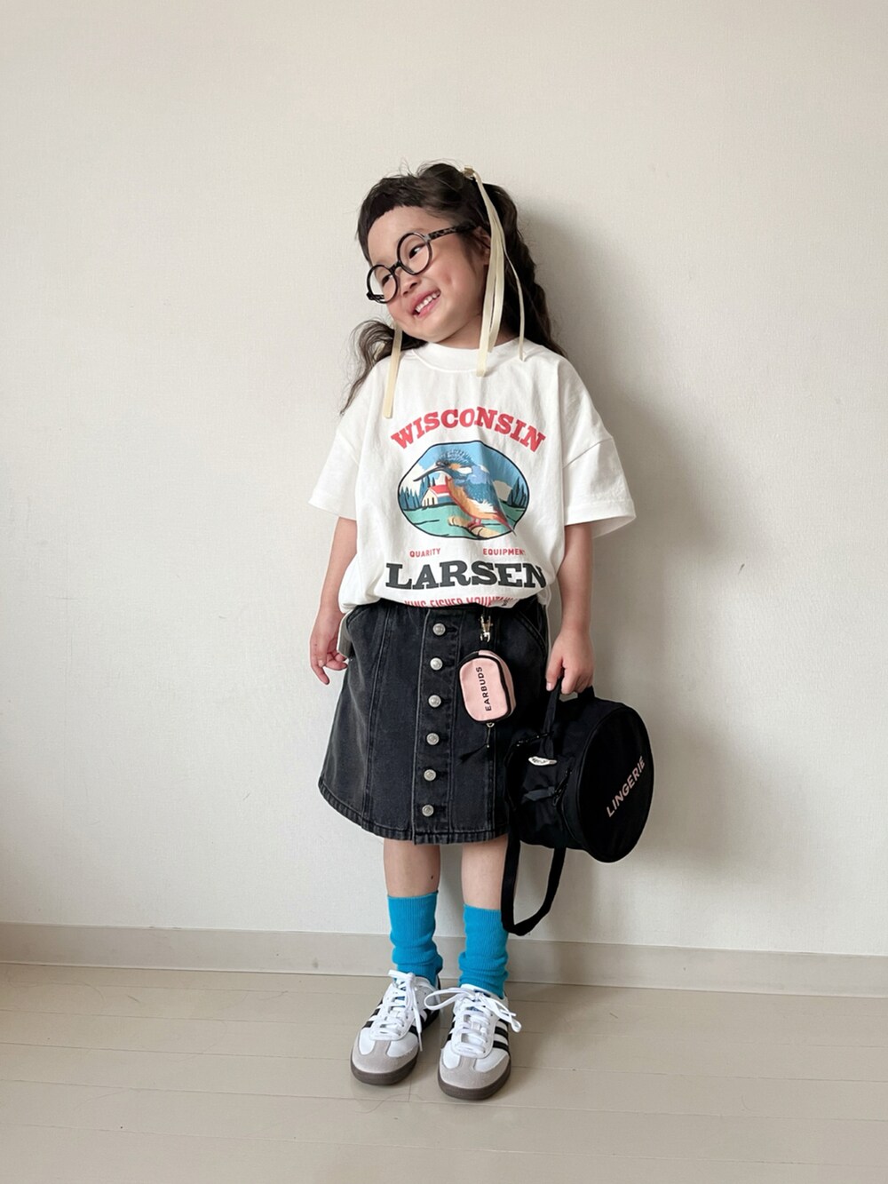 ホワイト系のTシャツ/カットソー、ブラック系のスカート、ホワイト系のスニーカーを着用したキッズの春コーディネートの2枚目の写真