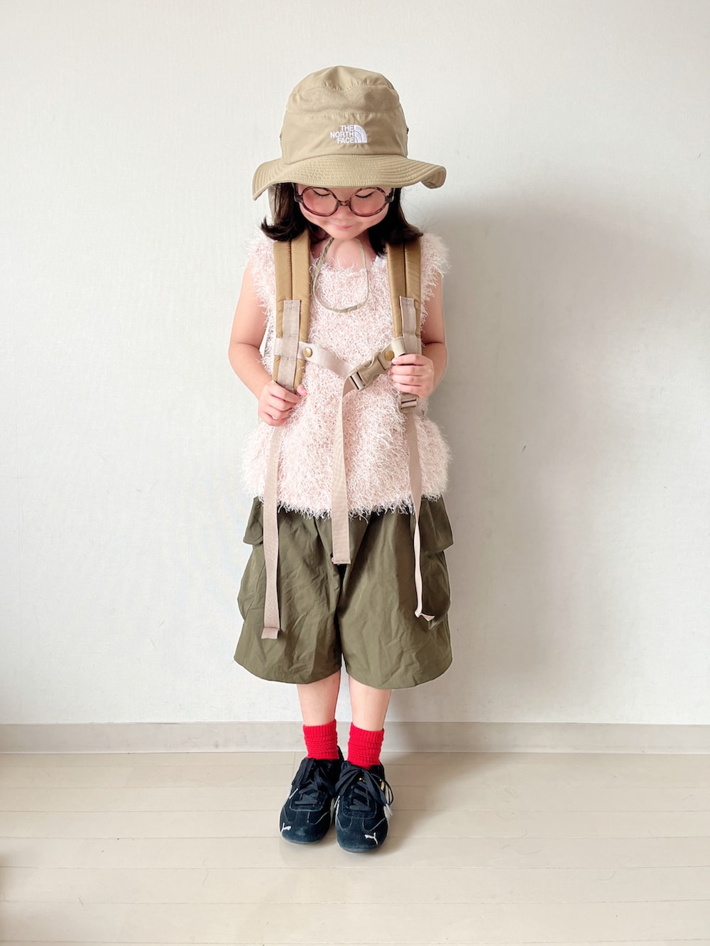 ピンク系のトップス、グリーン系のカーゴパンツ、ベージュ系のバックパック/リュックを着用したキッズの夏コーディネートの3枚目の写真