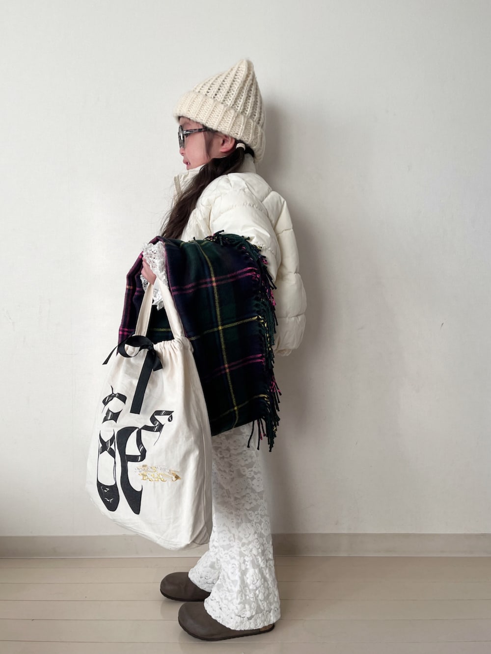 ホワイト系のダウンジャケット/コート、ホワイト系のニット/セーター、ホワイト系のTシャツ/カットソーを着用したキッズの冬コーディネートの4枚目の写真