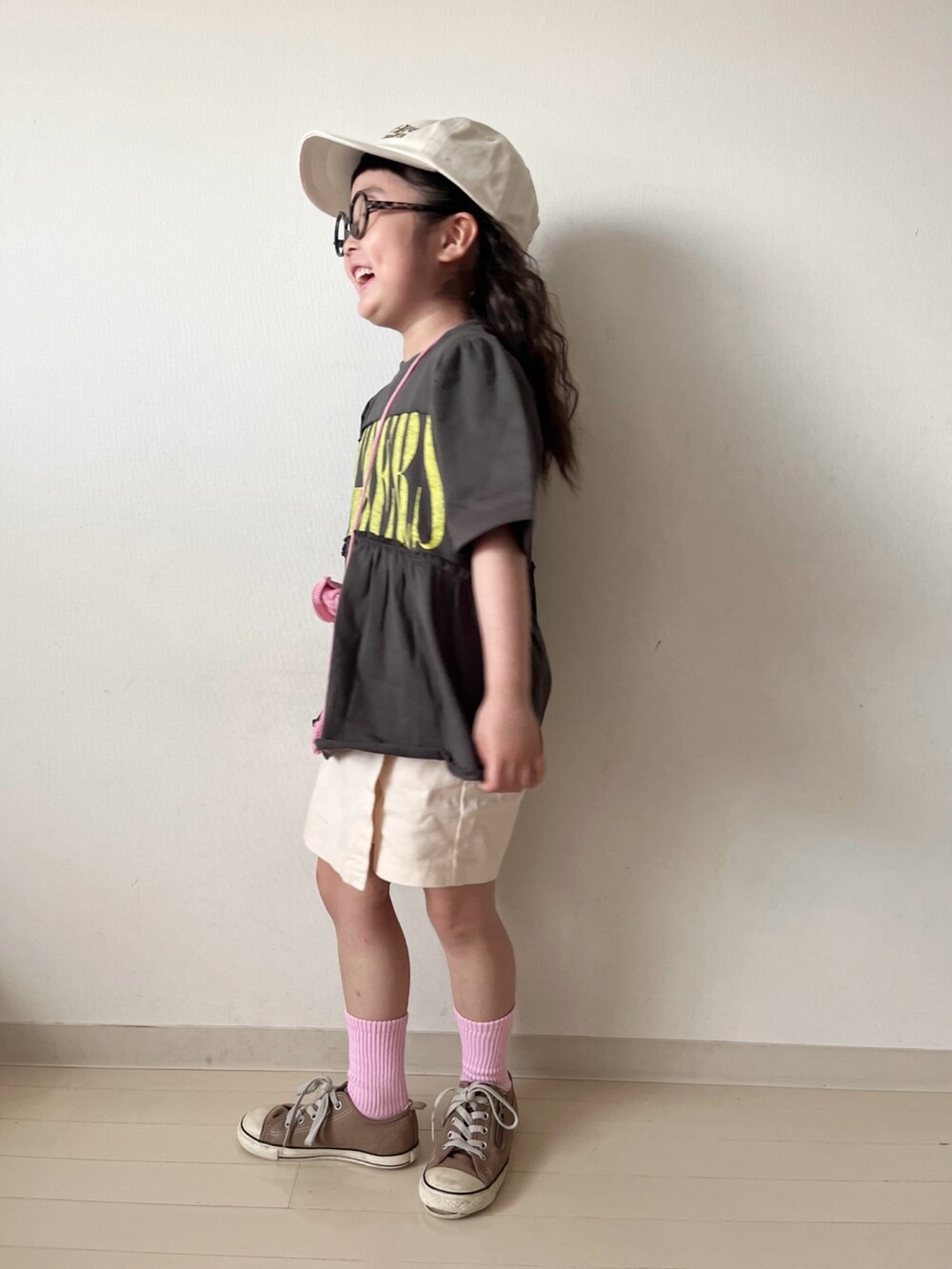 グレー系のワンピース、ホワイト系のその他パンツ、ピンク系のハンドバッグを着用したキッズの春コーディネートの3枚目の写真