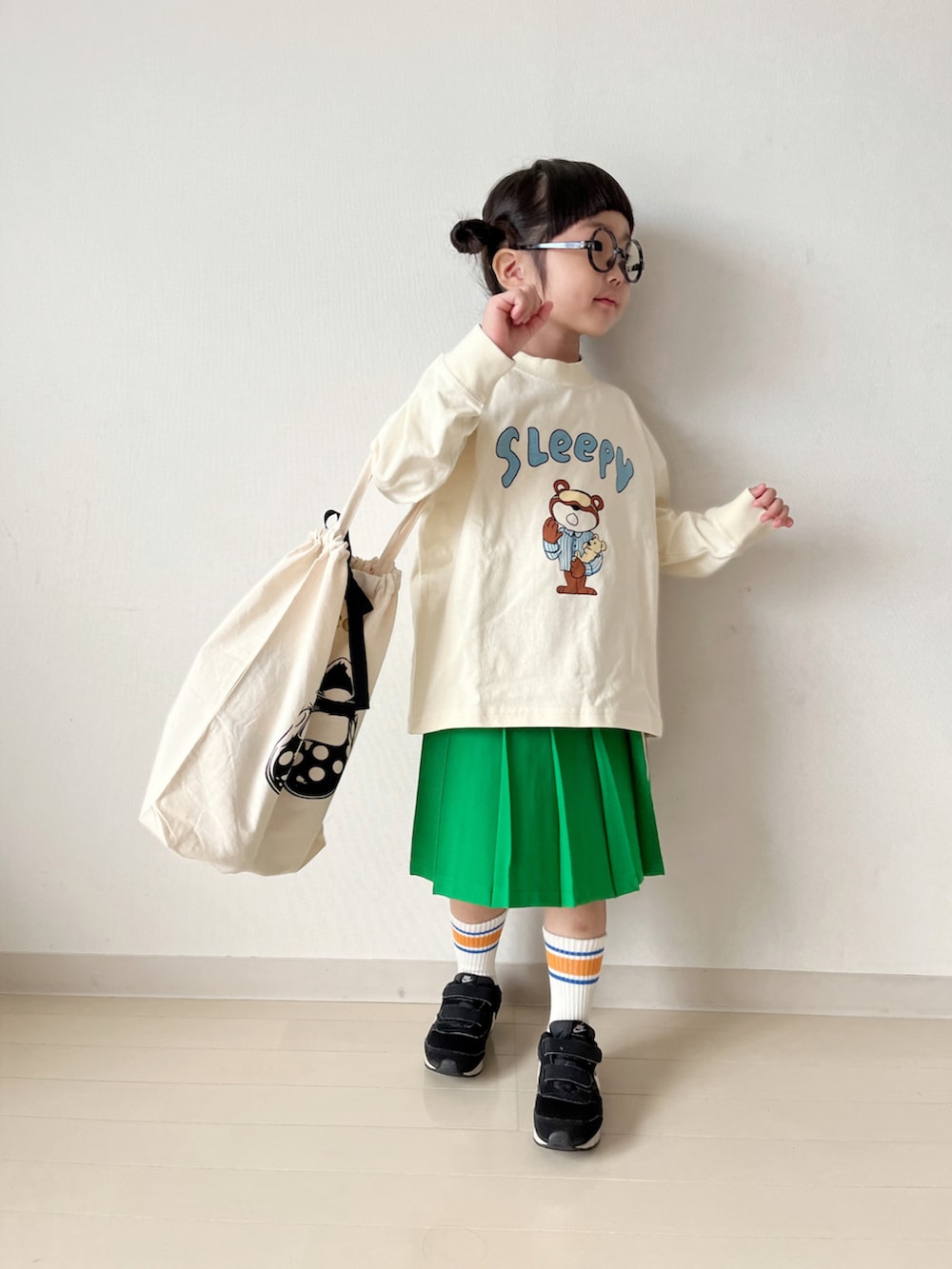 ホワイト系のTシャツ/カットソー、グリーン系のスカート、ブラック系のスニーカーを着用したキッズの秋コーディネートの3枚目の写真