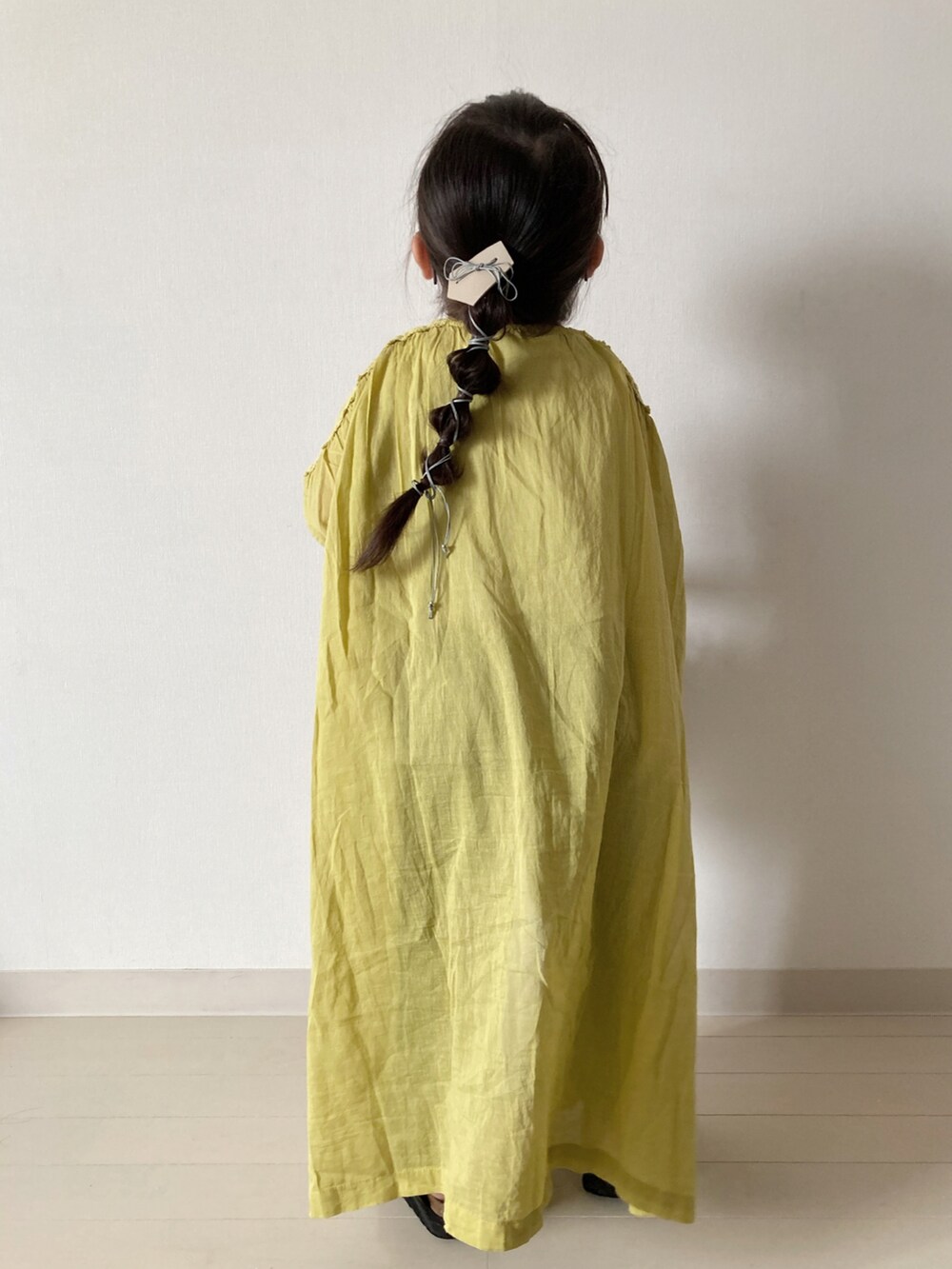 イエロー系のワンピース、グリーン系のTシャツ/カットソー、グリーン系のカーゴパンツを着用したキッズの春コーディネートの4枚目の写真