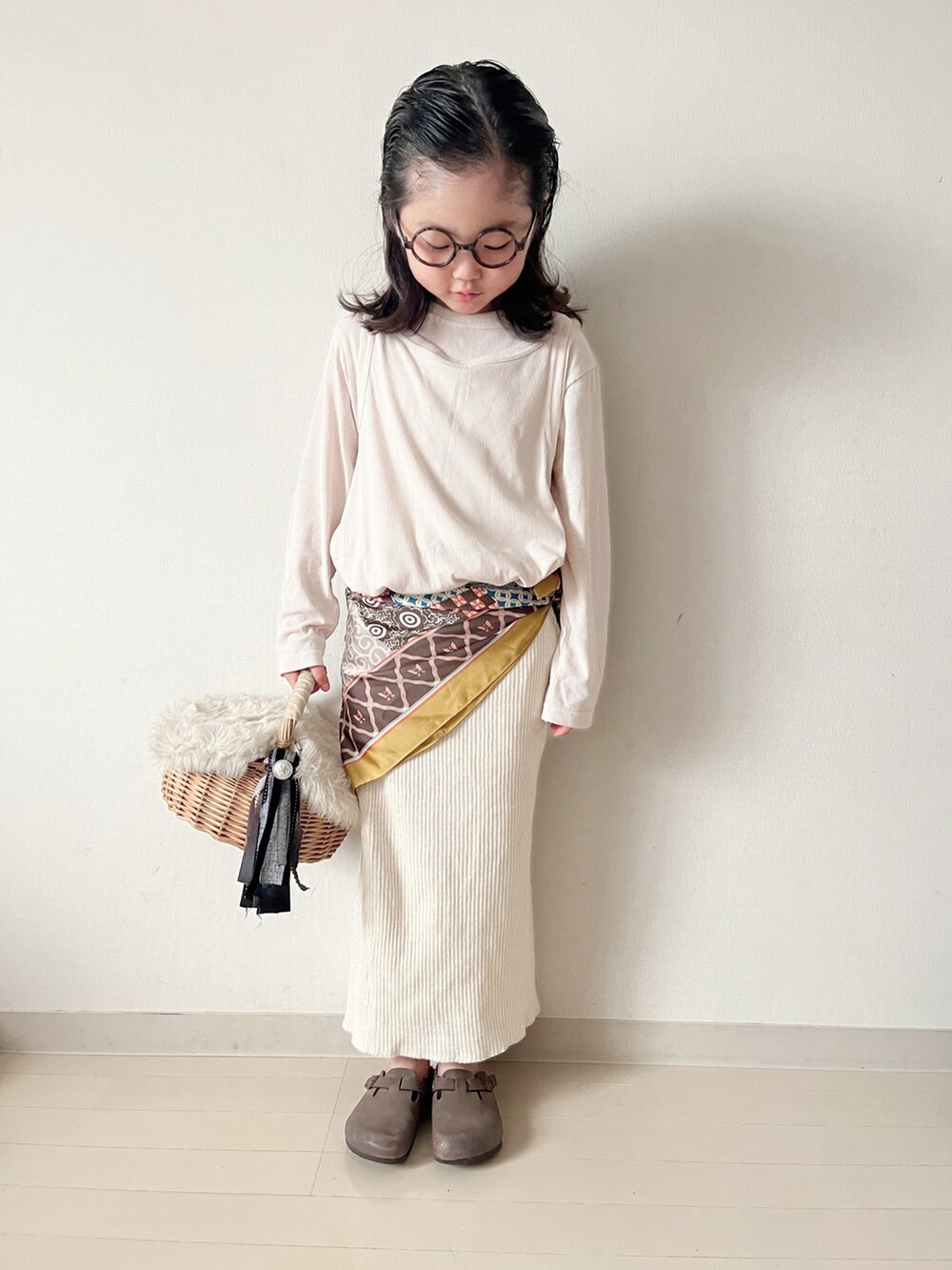ベージュ系のTシャツ/カットソー、ベージュ系のスカート、イエロー系のバンダナ/スカーフを着用したキッズの秋コーディネートの2枚目の写真