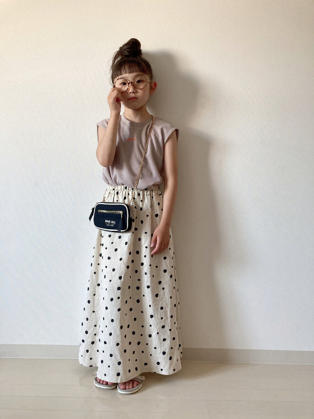 ホワイト系のスカート、グレー系のタンクトップ、ベージュ系のサンダルを着用したキッズの夏コーディネートの3枚目の写真