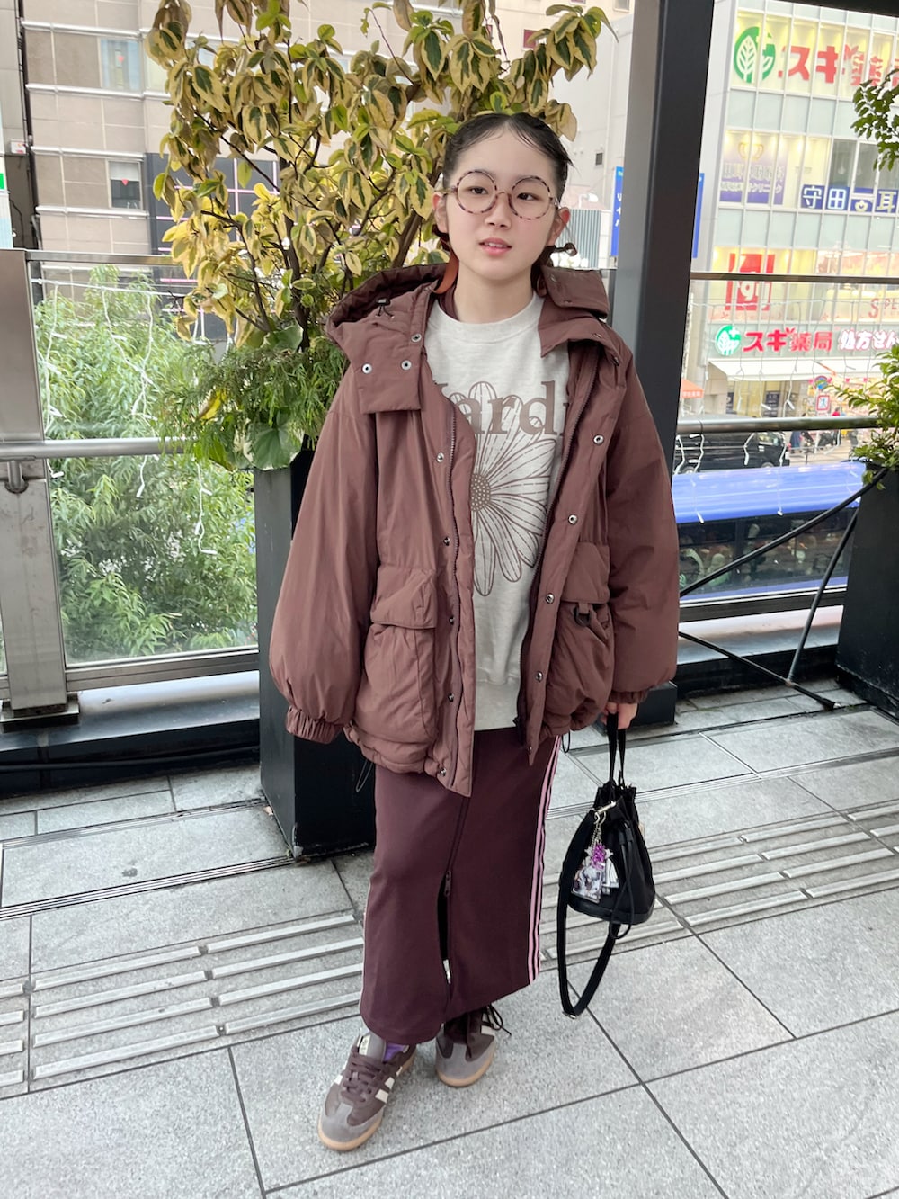 ベージュ系のスウェット、ブラウン系のブルゾン、ブラウン系のスカートを着用したキッズの冬コーディネートの2枚目の写真