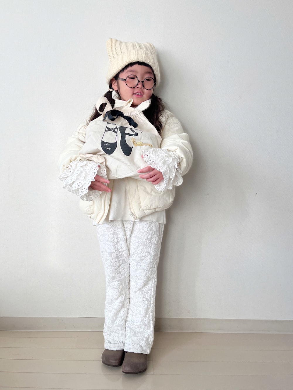 ホワイト系のダウンジャケット/コート、ホワイト系のニット/セーター、ホワイト系のTシャツ/カットソーを着用したキッズの冬コーディネートの2枚目の写真
