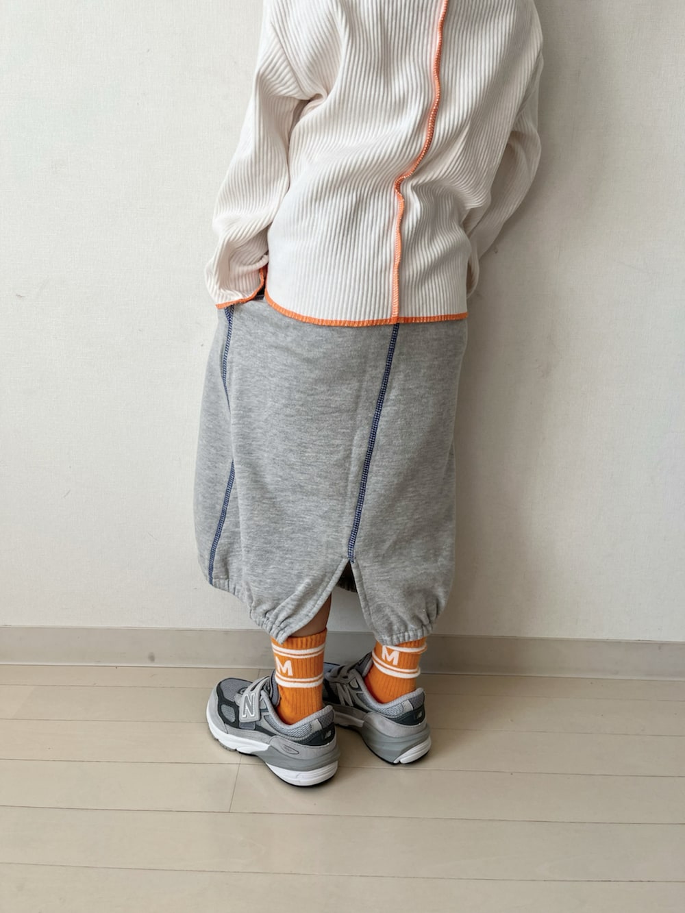 グレー系のTシャツ/カットソー、グレー系のスカート、ブラック系のMA-1を着用したキッズの冬コーディネートの5枚目の写真