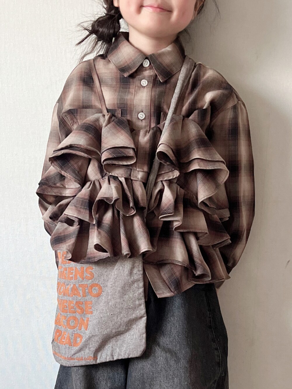 ブラウン系のシャツ/ブラウス、ブラック系のデニムパンツ、ブラウン系のキャミソールを着用したキッズの秋コーディネートの4枚目の写真