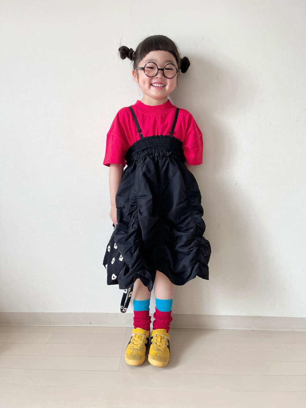 レッド系のTシャツ/カットソー、ブラック系のスカート、ブラック系のショルダーバッグを着用したキッズの春コーディネートの5枚目の写真