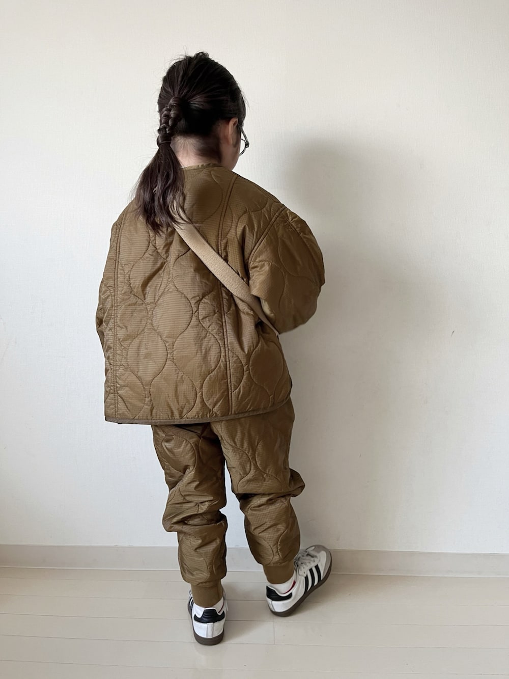 ブラウン系のダウンジャケット/コート、ブラウン系のその他パンツ、ブラック系のTシャツ/カットソーを着用したキッズの秋コーディネートの5枚目の写真