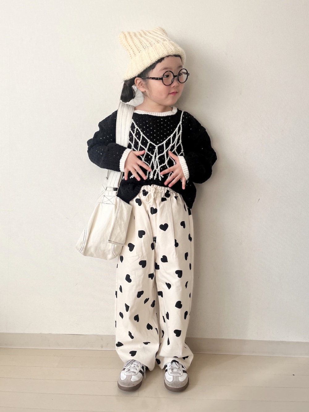 ホワイト系のダウンジャケット/コート、ホワイト系のその他パンツ、ブラック系のニット/セーターを着用したキッズの冬コーディネートの5枚目の写真