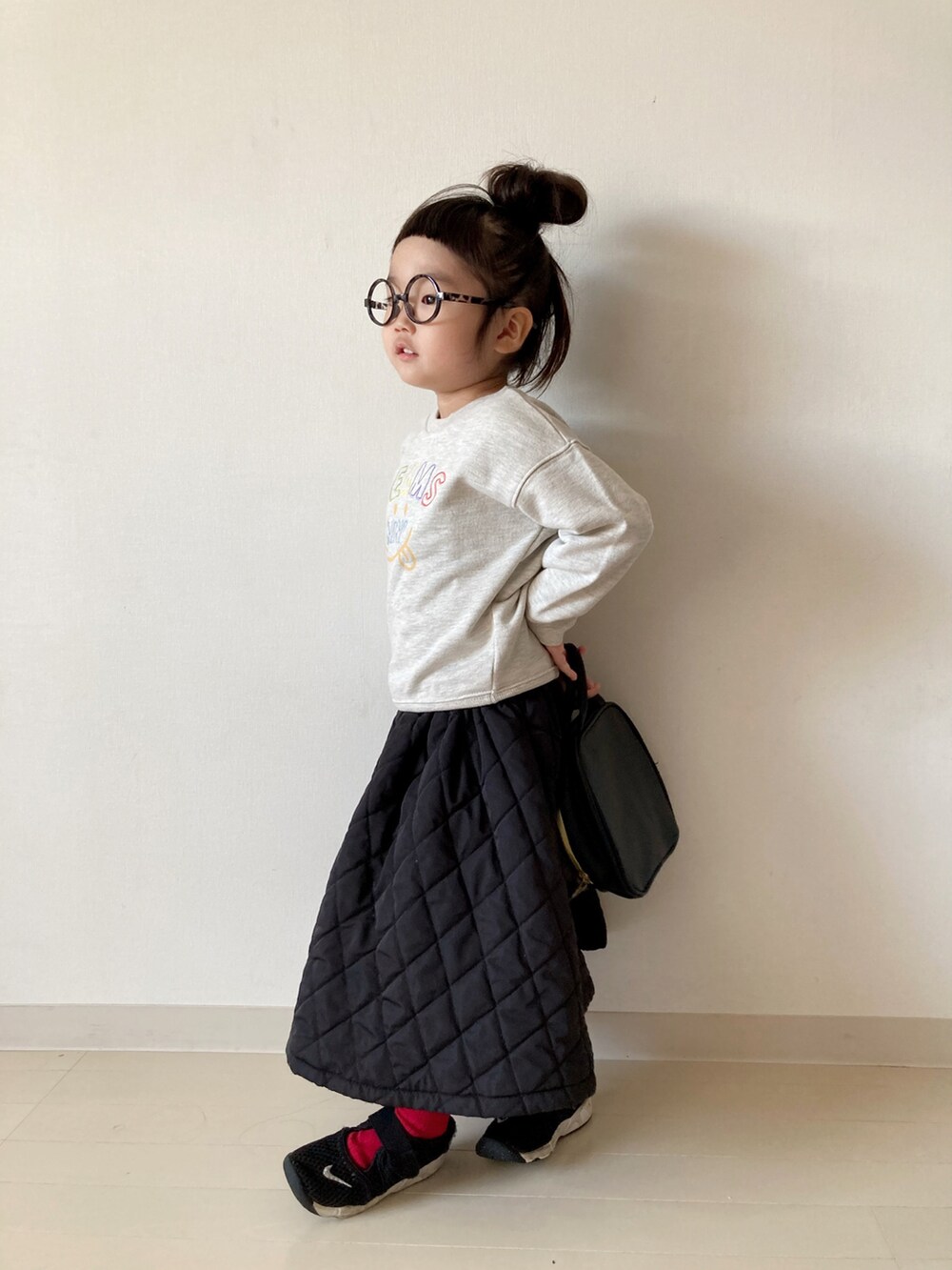 ホワイト系のスウェット、ブラック系のワンピース、ブラック系のスニーカーを着用したキッズの秋コーディネートの4枚目の写真