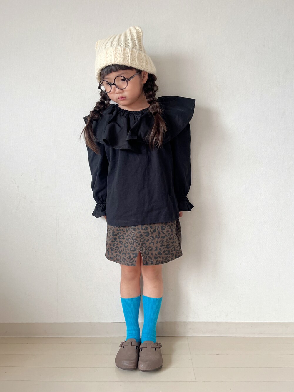 ブラック系のTシャツ/カットソー、ベージュ系のスカート、ブラウン系のサンダルを着用したキッズの秋コーディネートの3枚目の写真