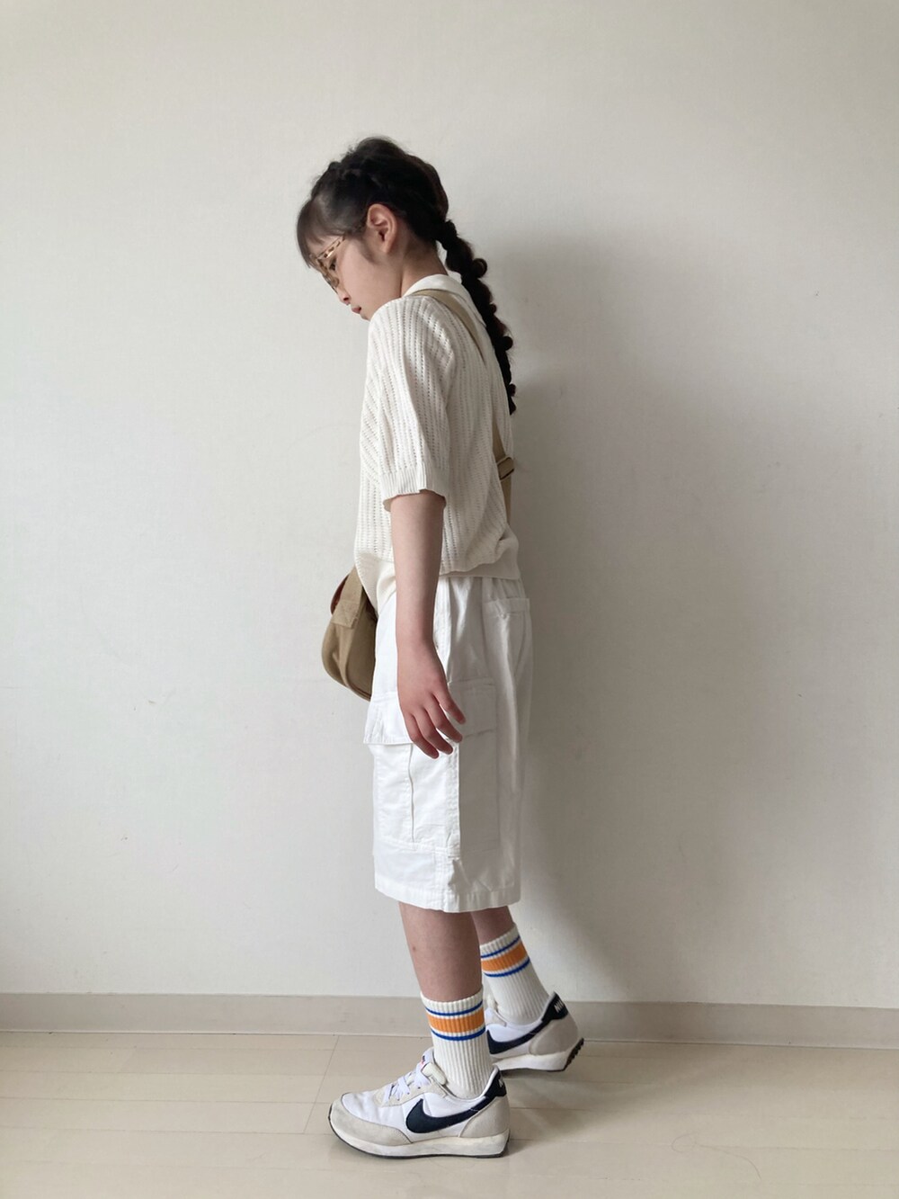 ホワイト系のカーゴパンツ、ホワイト系のカーディガン/ボレロ、ベージュ系のショルダーバッグを着用したキッズの春コーディネートの3枚目の写真