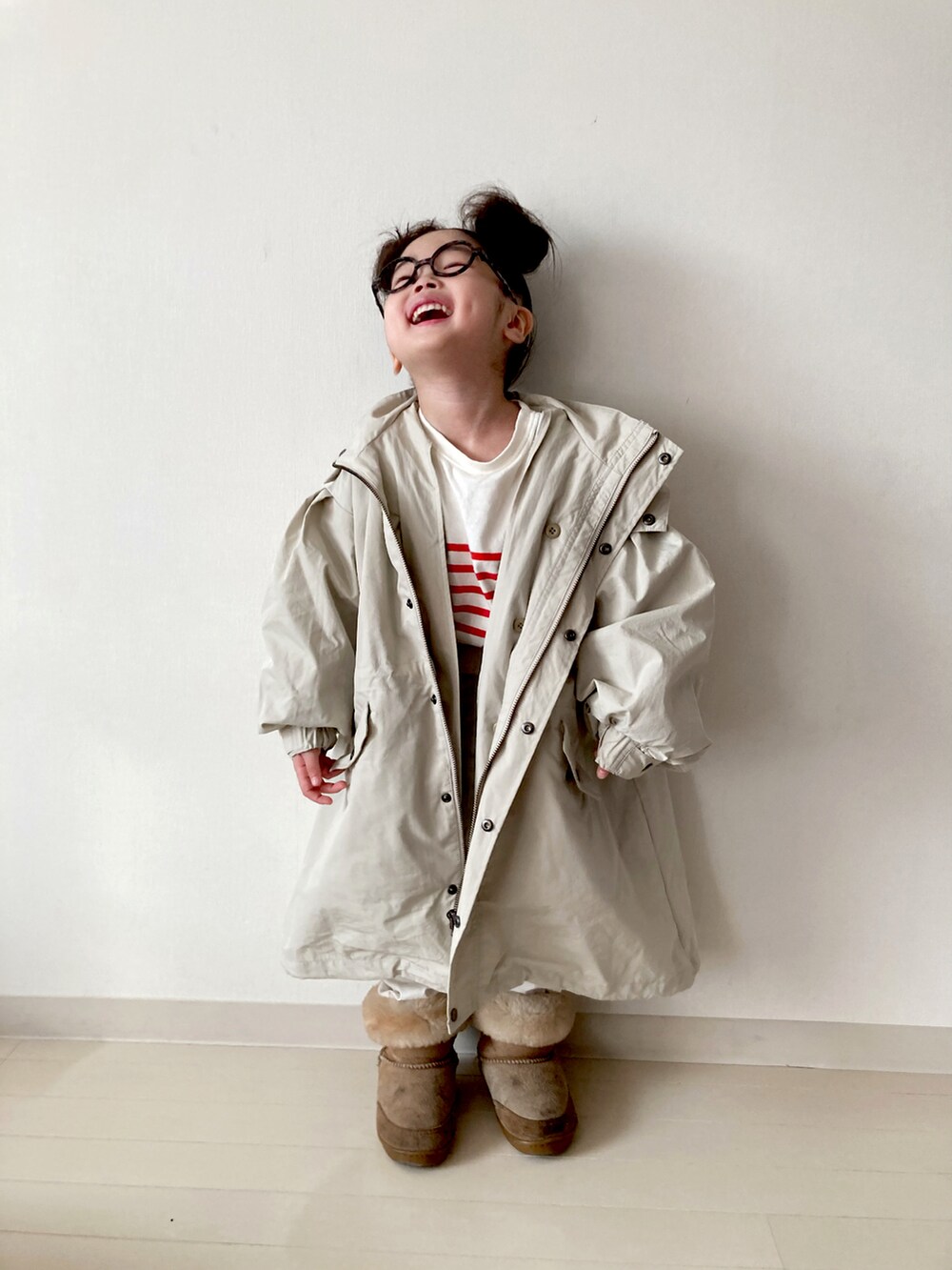 ベージュ系のモッズコート、ホワイト系のベスト、ホワイト系のその他パンツを着用したキッズの冬コーディネートの5枚目の写真