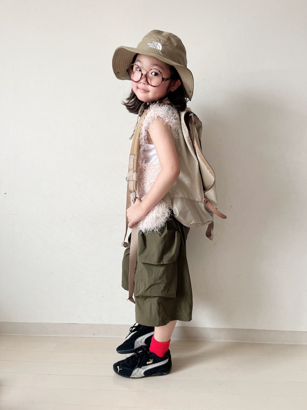 ピンク系のトップス、グリーン系のカーゴパンツ、ベージュ系のバックパック/リュックを着用したキッズの夏コーディネートの2枚目の写真