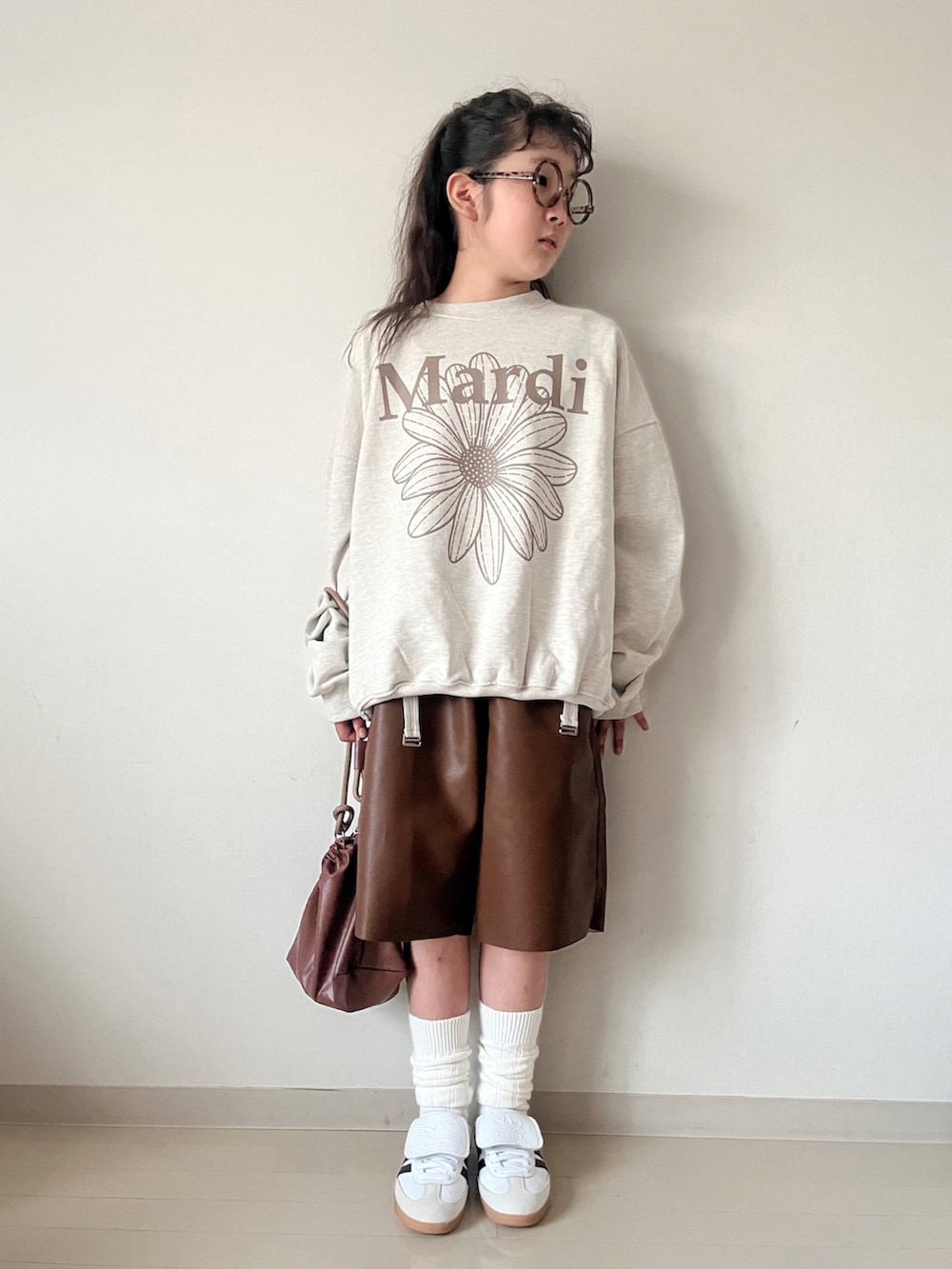 ベージュ系のスウェット、グリーン系のTシャツ/カットソー、ブラウン系のショルダーバッグを着用したキッズの秋コーディネートの5枚目の写真