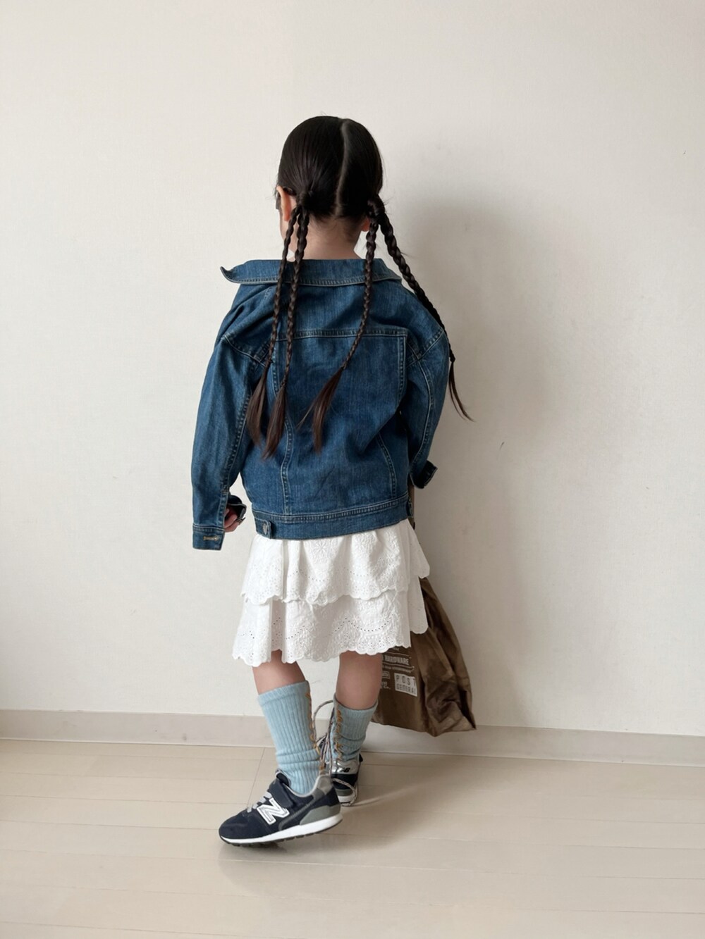 パープル系のTシャツ/カットソー、ホワイト系のスカート、ブルー系のデニムジャケットを着用したキッズの春コーディネートの5枚目の写真