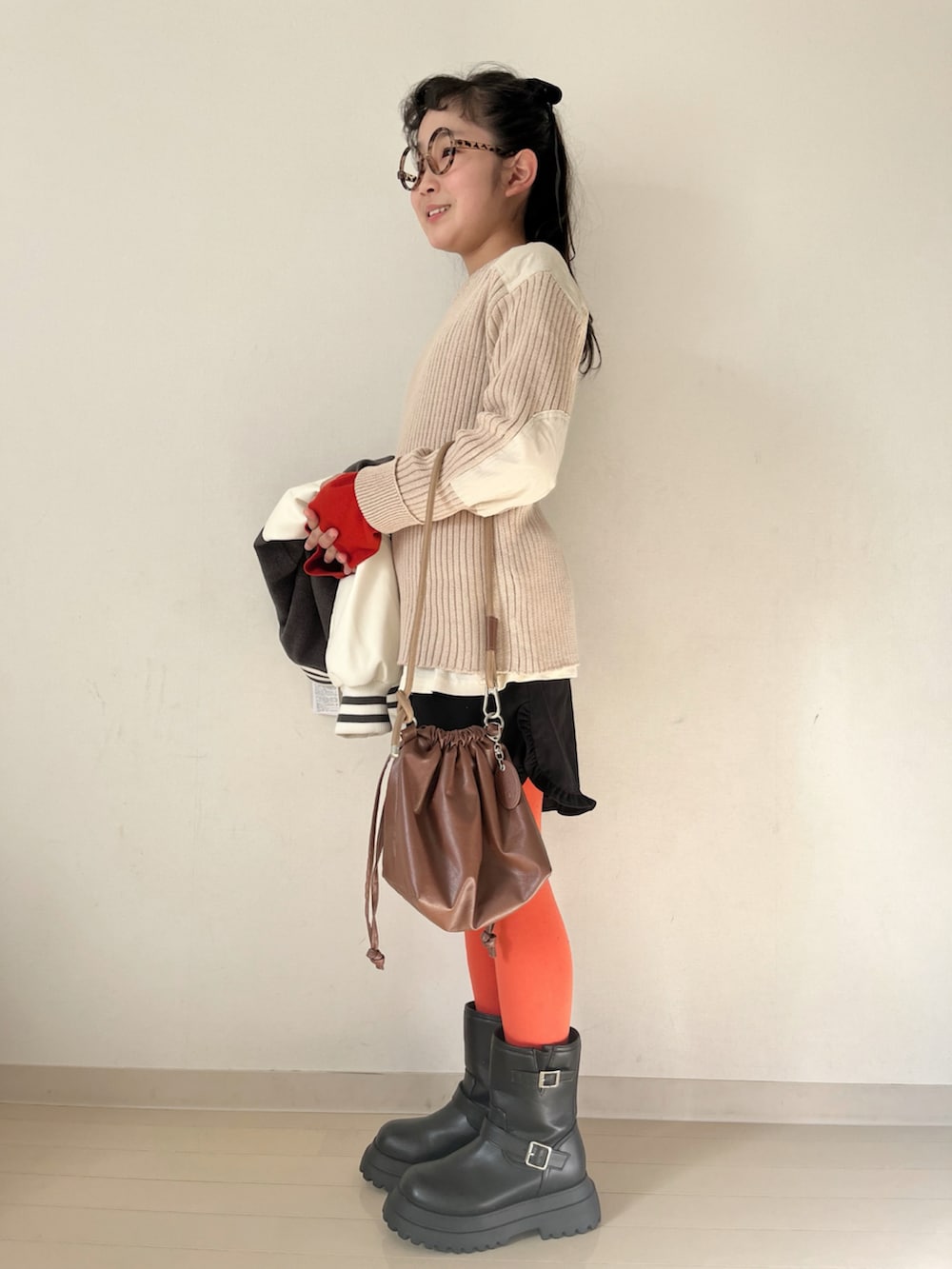 ホワイト系のニット/セーター、ホワイト系のTシャツ/カットソー、グレー系のスタジャンを着用したキッズの秋コーディネートの3枚目の写真