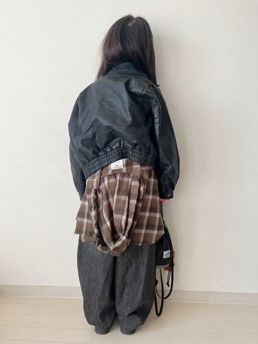 ブラウン系のトップス、ブラック系のデニムパンツ、ブラック系のタンクトップを着用したキッズの冬コーディネートの5枚目の写真