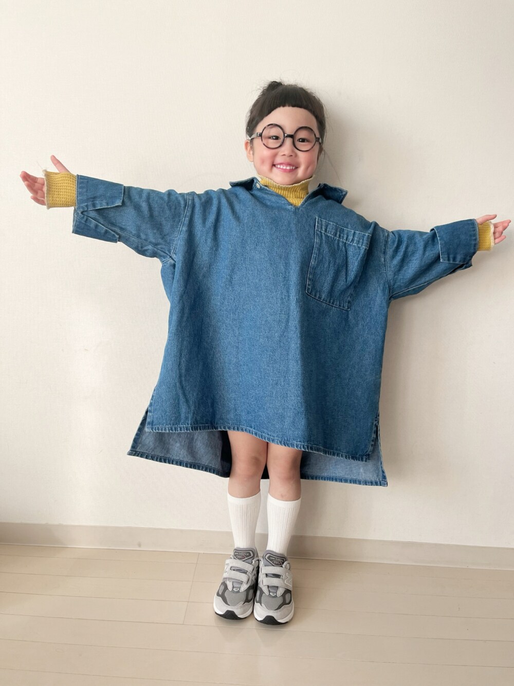 ブルー系のワンピース、イエロー系のTシャツ/カットソー、グレー系のスニーカーを着用したキッズの冬コーディネートの2枚目の写真