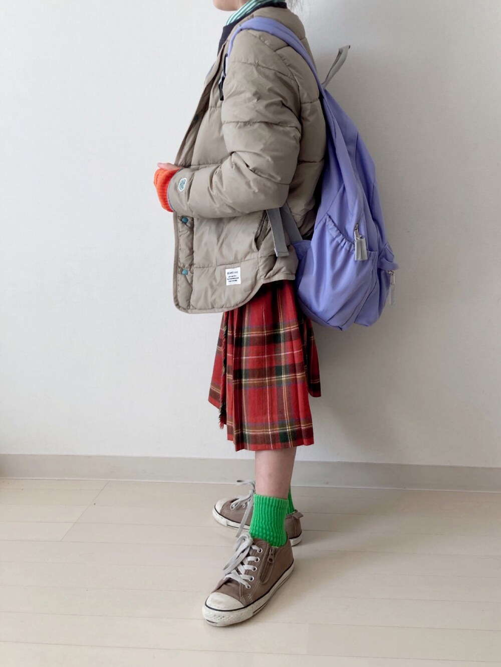 ブラウン系のブルゾン、グレー系のスウェット、レッド系のスカートを着用したキッズの秋コーディネートの5枚目の写真