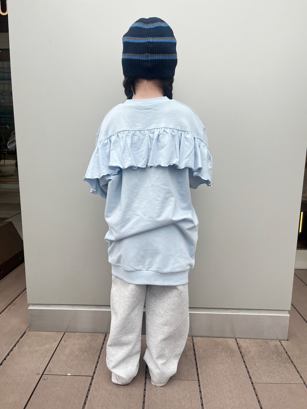 ブルー系のワンピース、グレー系のスウェットパンツ、ホワイト系のスニーカーを着用したキッズの春コーディネートの5枚目の写真