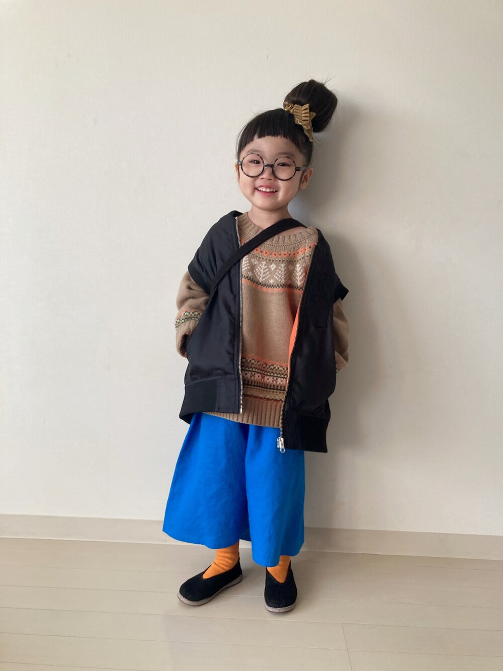 ベージュ系のニット/セーター、ブルー系のスカート、ブラック系のベストを着用したキッズの冬コーディネートの5枚目の写真