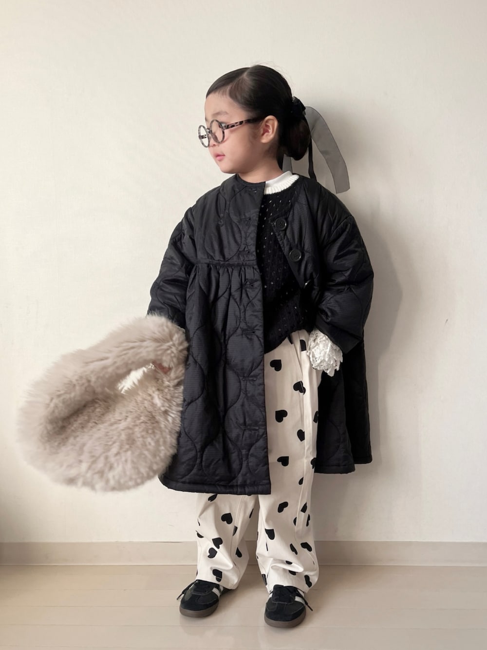 ブラック系のミリタリージャケット、ブラック系のニット/セーター、ホワイト系のTシャツ/カットソーを着用したキッズの秋コーディネートの3枚目の写真