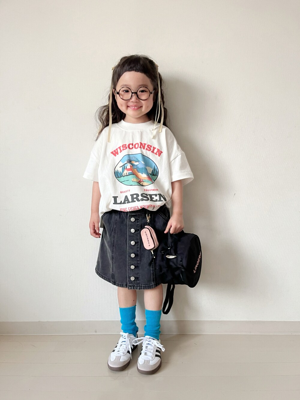 ホワイト系のTシャツ/カットソー、ブラック系のスカート、ホワイト系のスニーカーを着用したキッズの春コーディネートの5枚目の写真