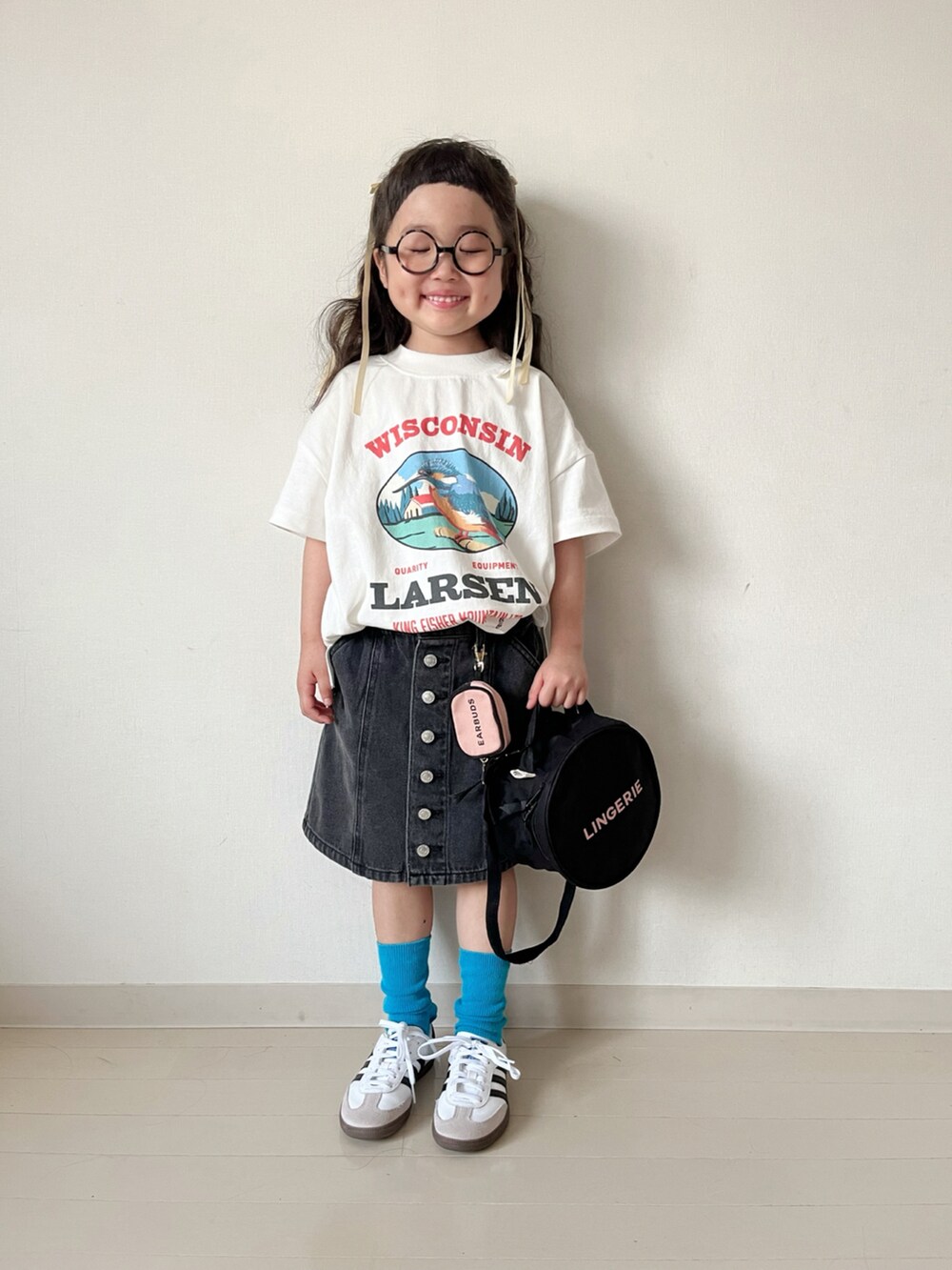 ホワイト系のTシャツ/カットソー、ブラック系のスカート、ホワイト系のスニーカーを着用したキッズの春コーディネートの4枚目の写真