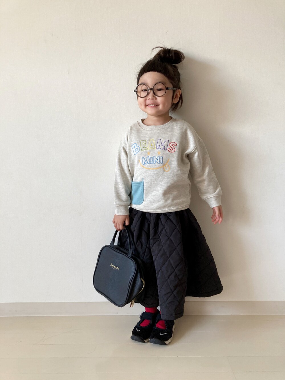 ホワイト系のスウェット、ブラック系のワンピース、ブラック系のスニーカーを着用したキッズの秋コーディネートの3枚目の写真