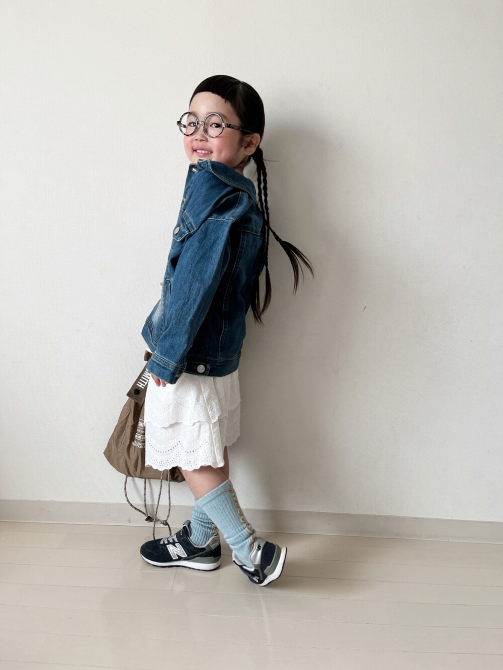 パープル系のTシャツ/カットソー、ホワイト系のスカート、ブルー系のデニムジャケットを着用したキッズの春コーディネートの4枚目の写真