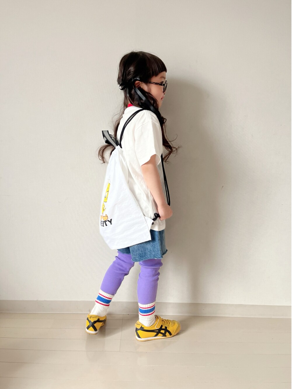 ホワイト系のTシャツ/カットソー、ホワイト系のバックパック/リュック、イエロー系のスニーカーを着用したキッズの春コーディネートの5枚目の写真