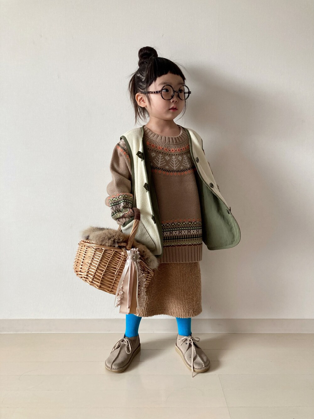 ベージュ系のニット/セーター、グリーン系のベスト、ベージュ系のTシャツ/カットソーを着用したキッズの冬コーディネートの2枚目の写真