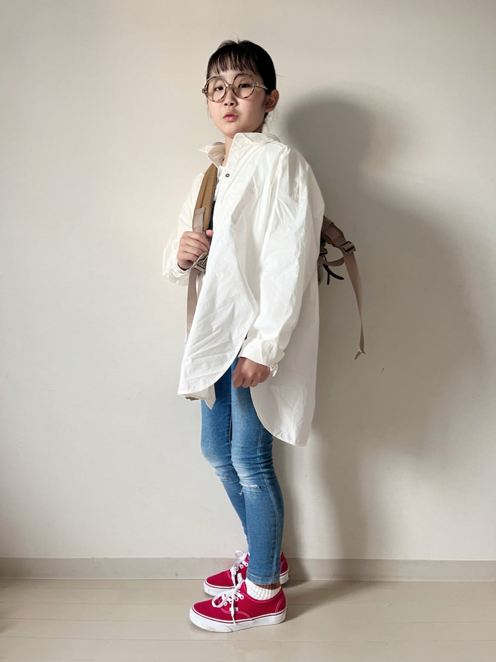 ホワイト系のTシャツ/カットソー、ブルー系のデニムパンツ、ホワイト系のシャツ/ブラウスを着用したキッズの秋コーディネートの3枚目の写真